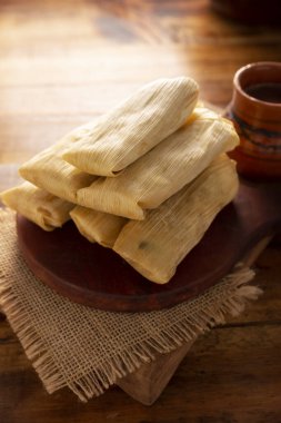 Tamale. Meksika ve bazı Latin Amerika ülkelerinin tipik antipatik yemekleri. Mısır yaprağına sarılmış mısır hamuru. Tamaleler buğulandı..