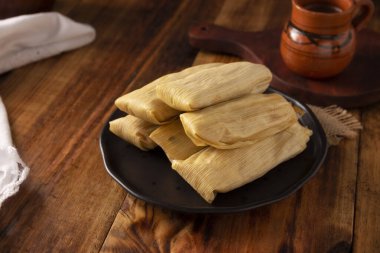 Tamale. Meksika ve bazı Latin Amerika ülkelerinin tipik antipatik yemekleri. Mısır yaprağına sarılmış mısır hamuru. Tamaleler buğulandı.. 