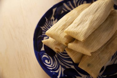 Tamale. Meksika ve bazı Latin Amerika ülkelerinin tipik antipatik yemekleri. Mısır yaprağına sarılmış mısır hamuru. Tamaleler buğulandı..