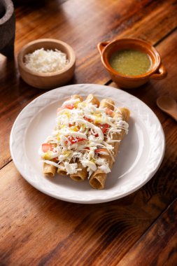 Tacos Dorados. Flautas olarak da bilinen Meksika yemeği, dolgulu mısır tortillasından oluşur, yaygın olarak tavuk veya sığır eti veya patates gibi vejetaryen seçenekleri içerir..