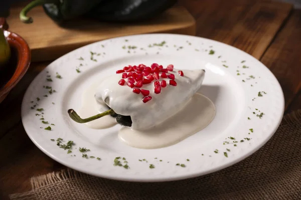 Chile en Nogada, Typical dish from Mexico. Prepared with poblano chili stuffed with meat and fruits and covered with a walnut sauce. Named as the quintessential Mexican dish for national holidays.