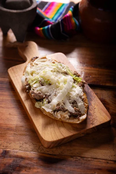 Huarache 典型的墨西哥椭圆形菜肴 由玉米面和豆子制成 通常覆有生菜 酱汁和一些蛋白质 如牛排 排骨或鸡蛋 — 图库照片