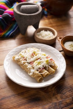 Tacos Dorados. Flautas olarak da bilinen Meksika yemeği, dolgulu mısır tortillasından oluşur, yaygın olarak tavuk veya sığır eti veya patates gibi vejetaryen seçenekleri içerir..