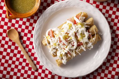 Tacos Dorados. Flautas olarak da bilinen Meksika yemeği, dolgulu mısır tortillasından oluşur, yaygın olarak tavuk veya sığır eti veya patates gibi vejetaryen seçenekleri içerir..