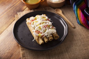 Tacos Dorados. Flautas olarak da bilinen Meksika yemeği, dolgulu mısır tortillasından oluşur, yaygın olarak tavuk veya sığır eti veya patates gibi vejetaryen seçenekleri içerir..