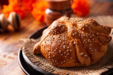 Pan de Muerto. Ölü sezonunda tüketilen susam tohumlu tipik Meksika tatlı ekmeği. Sunaklarda ve sunaklarda temel bir unsurdur.