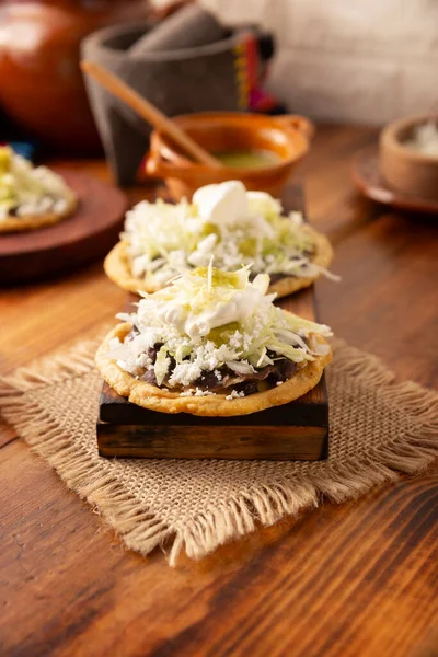 索菲亚传统的墨西哥自制食品 用扁平的墨西哥面团和夹在用豆子 绿色或红色酱汁 洋葱和酸奶制成的边境油炸玉米面上 — 图库照片