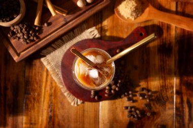 Buzlu kahve, çift katlı cam bardak ve metal pipetle servis edilir. Buz küpleri ve baharatlar, tarçın, hindistan cevizi, vanilya, muskovado şekeri ve kremayla hazırlanmış soğuk bir yaz içeceği..