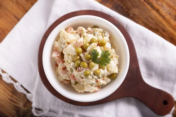 Russian Salad, also known as Olivier Salad. Very popular dish in several countries, the main ingredients are commonly potatoes, mayonnaise and vegetables such as peas, carrots, boiled eggs or chicken