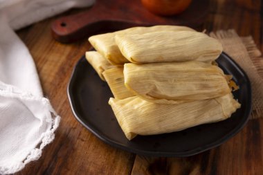 Tamale. Meksika ve bazı Latin Amerika ülkelerinin tipik İspanyol yemekleri. Mısır yaprağına sarılmış mısır hamuru. Tamaleler buğulandı..