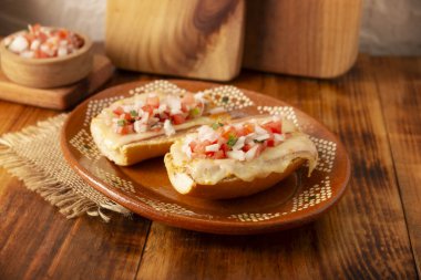 Köstebekler. Meksika tarifi bolillo ekmeğine dayanır. Uzun uzadıya bölünmüş, kızarmış fasulye ve graten peyniri ile yayılmış, pico de gallo sosu ve jambon, domuz pastırması veya sucuk gibi proteinler eklenmiş..