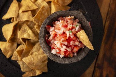 Geleneksel Meksika Pico de Gallo sosu, soğan, domates, kişniş, yeşil biber, tuz ve limon suyuyla yapılan kolay ve sağlıklı bir tarif. Taş bir molcajete 'de servis edilmiş..