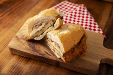 Meksikalı Torta de Milanesa. Bolillo ekmeği, telera ya da baget ekmeği ile yapılmış sandviç, ikiye bölünmüş ve çeşitli malzemelerle doldurulmuş, bu durumda Oaxaca peynirli tavuk eti..