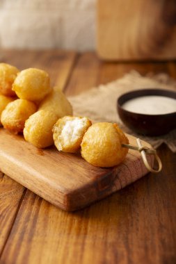 Kızarmış peynirli toplar, kolay ve lezzetli ev yapımı aperatif tarifi. Sos ile servis edilir..