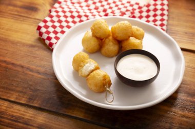 Kızarmış peynirli toplar, kolay ve lezzetli ev yapımı aperatif tarifi. Sos ile servis edilir..