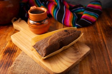 Çikolatalı Tamale. Meksika ve bazı Latin Amerika ülkelerinin tipik İspanyol yemekleri. Mısır yaprağına sarılmış mısır hamuru. Tamaleler buğulandı. Yanında genellikle atole, sıcak çikolata ya da kahve olur.