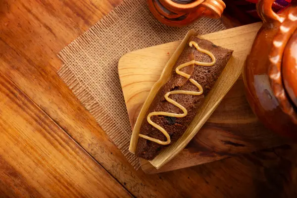 Çikolatalı Tamale. Meksika ve bazı Latin Amerika ülkelerinin tipik İspanyol yemekleri. Mısır yaprağına sarılmış mısır hamuru. Tamaleler buğulandı. Yanında genellikle atole, sıcak çikolata ya da kahve olur.