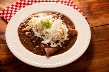 Enfrijoladas. Fasulye sosuna batırılmış, krem ve peynirle kaplanmış mısır tortillaları ya da tavuk eti, peynir ya da başka bir malzemeyle doldurulabilirler. Geleneksel Meksika yemeği.