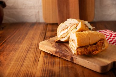 Meksikalı Torta de Milanesa. Bolillo ekmeği, telera ya da baget ekmeği ile yapılmış sandviç, ikiye bölünmüş ve çeşitli malzemelerle doldurulmuş, bu durumda Oaxaca peynirli tavuk eti..