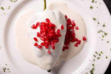 Chiles en Nogada, Meksika 'dan tipik bir yemek. Et, meyve ve ceviz sosu, maydanoz ve nar ile doldurulmuş poblano biberiyle hazırlanmış..