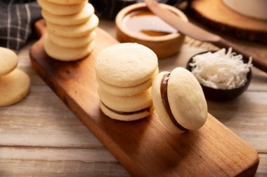 Alfajor. Latin Amerika 'da popüler olan geleneksel bir tatlı, iki kurabiyeyi birleştirip toz şeker, rendelenmiş hindistan cevizi veya çikolatayla kaplı bir sandviç oluşturur..