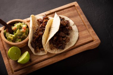 Biftekli taco. Meksika 'da Taco de Bistec ya da Carne Asada adında çok popüler bir taco, mısır tortilla üzerinde servis edilen ev yapımı biftek. Meksika sokak yemeği.