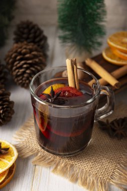 Baharatlı şarap veya Noel şarabı portakal, tarçın, yıldız anason, karanfil, hindistan cevizi ve diğer malzemelerle ahşap bir masa. Kış ve Noel tatillerinde geleneksel sıcak içecek..