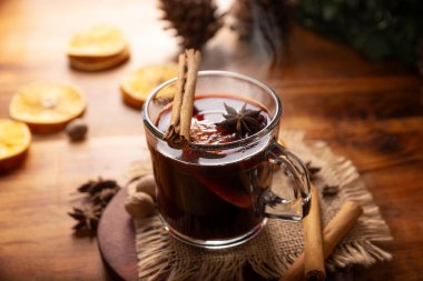 Baharatlı şarap veya Noel şarabı portakal, tarçın, yıldız anason, karanfil, hindistan cevizi ve diğer malzemelerle ahşap bir masa. Kış ve Noel tatillerinde geleneksel sıcak içecek..