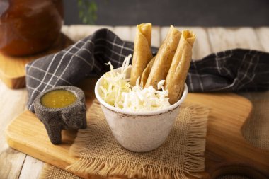 Flautas Ahogadas (Boğulmuş Flautas) kızarmış mısır tortillasıyla yapılmış altın tacolar, tavuk veya sığır eti ile doldurulmuş ve içinde salsa veya et suyu, marul, ekşi krema ve peynir bulunan bir bardak veya bardakta servis edilmiştir..