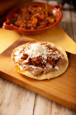 Köfteli tinga tostu, Meksika usulü geleneksel ev yapımı et, öncelikle acı biberli ve bol soğanlı, geleneksel olarak Tostadas 'ta yenir (kızarmış mısır tortillası).).