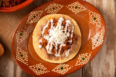 Köfteli tinga tostu, Meksika usulü geleneksel ev yapımı et, öncelikle acı biberli ve bol soğanlı, geleneksel olarak Tostadas 'ta yenir (kızarmış mısır tortillası).).
