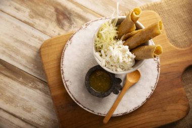 Flautas Ahogadas (Boğulmuş Flautas) kızarmış mısır tortillasıyla yapılmış altın tacolar, tavuk veya sığır eti ile doldurulmuş ve içinde salsa veya et suyu, marul, ekşi krema ve peynir bulunan bir bardak veya bardakta servis edilmiştir..