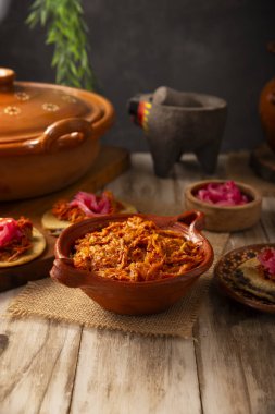 Cochinita Pibil. Yucatan 'dan tipik Meksika güveci, fındıklı terbiye edilmiş domuz eti ve yanında fasulye ve kırmızı soğanlı habanero biberi.