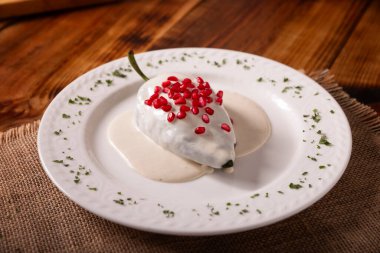 Chiles en Nogada, tipik bir Meksika yemeği. Et ve meyveyle doldurulmuş Poblano Şili ceviz, maydanoz ve nar sosuyla kaplı. Meksika ulusal bayramlarında bir gelenek.