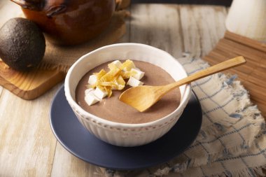 Creamy bean soup. In Mexico known as Crema de Frijoles, nutritious homemade food recipe, commonly accompanied with cheese, cream, avocado and corn tortilla cut into strips and fried.