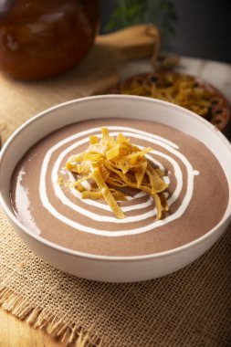 Creamy bean soup. In Mexico known as Crema de Frijoles, nutritious homemade food recipe, commonly accompanied with cheese, cream, avocado and corn tortilla cut into strips and fried.