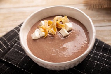 Creamy bean soup. In Mexico known as Crema de Frijoles, nutritious homemade food recipe, commonly accompanied with cheese, cream, avocado and corn tortilla cut into strips and fried.