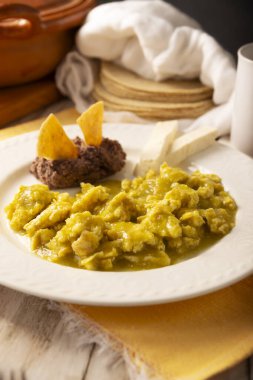 Scrambled eggs in green sauce. A typical Mexican breakfast of scrambled eggs tossed in spicy green sauce, usually accompanied by beans and pot coffee.