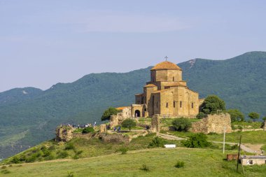 Güney yamacındaki dağdan Jvari manastırı. Turistler kiliseye girmeye hazır..