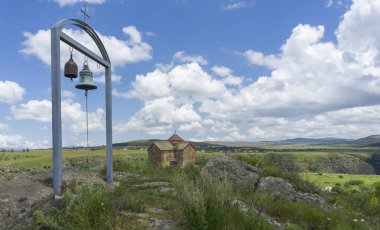 Demir kemerli bir çerçevede iki çan ve kumtaşı bir kilise. Georgia