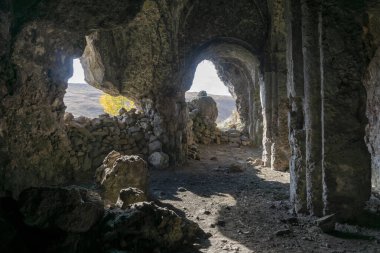 Inside in an antique rock-hewn church. Columns with arches and bas-reliefs. Samsari, Georgia clipart