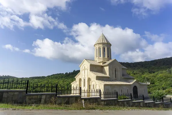 Kiketi köyünün Saint Ekvtime kilisesinin önündeki güzel metal çitler. Gökyüzü, bulutlar ve dağlar