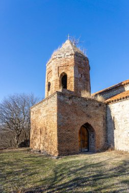Alvani köyünün Vaftizci Bazilikası Aziz John 'un çan kulesi. Turuncu tuğlalar duvar. Parlak mavi gökyüzü.