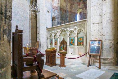 Samtavisi Katedrali 'nin içi. Simgeler, duvarda freskler, yanan mumlar, güzel bir avize.