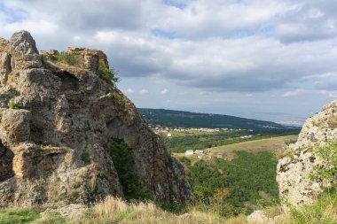 Kojori kalesinin tepesinde. Duvarın yıkıntıları ve taş ve tuğladan yapılmış kule. Yakınlardaki dağ ve köylerin manzarası. Açık mavi gökyüzü ve bulutlar. Georgia.