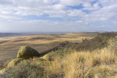 Dağların ve tarlaların manzarası. Kuru turuncu çimenler. Parlak mavi, bulutlu sinsi. Gürcistan 'ın çöl bölgesi.