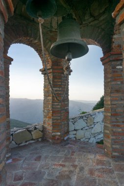 St. Giorgi kilisesinin çan kulesi. Tuğla kemerler. İple iki bronz çan. Dağların manzarası. Georgia, Udzo Manastırı.