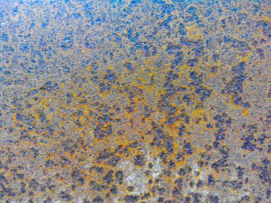 Paslı bir demir levha. Aşınmayla kaplı. Kahverengiden maviye dönüşüyor.