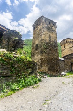 Dik bir toprak yol taştan bir kuleye çıkıyor. Ushguli köyünün kale kuleleri ve caddeleri.