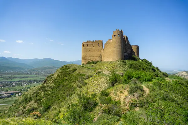 stock image View of the hill with the fortress of Ksani, villages and mountains. Towers and partially destroyed stone walls with loopholes are visible